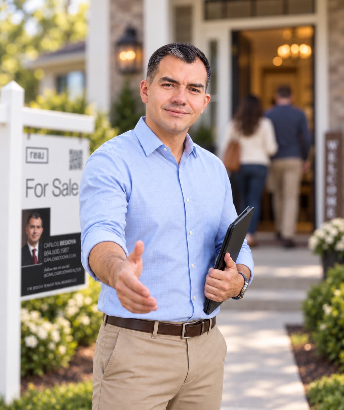 Carlos Bedoya greeting a couple at an open house, the welcome sign behind him